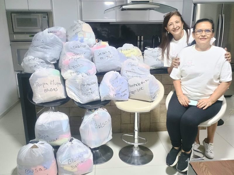 Voluntarias con bolsas de ropa clasificada para donar