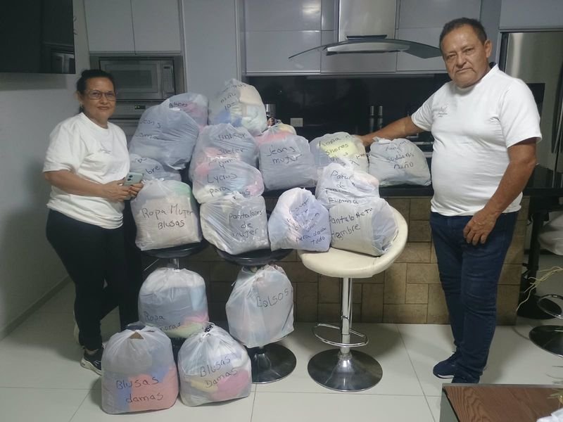 Voluntarios con las bolsas de ropa donada listas para entregar